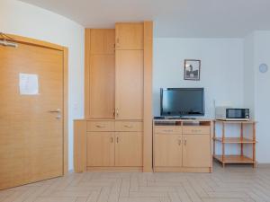 Cette chambre dispose d'armoires en bois, d'une télévision et d'une porte. dans l'établissement Apartment Mlasina-3 by Interhome, à Nin