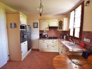een keuken met witte kasten en een wastafel bij Holiday Home Madaillan - PRY300 by Interhome in Madaillan