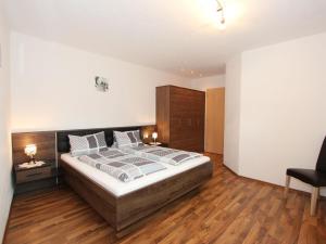 ein Schlafzimmer mit einem großen Bett und Holzböden in der Unterkunft Apartment Hanna by Interhome in Kaltenbach