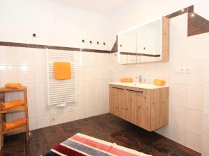 ein weißes Badezimmer mit einem Waschbecken und einem Spiegel in der Unterkunft Apartment Hanna by Interhome in Kaltenbach