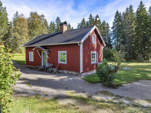 uma casa vermelha com uma chaminé por cima em Holiday Home Aspenäs by Interhome em Falköping
