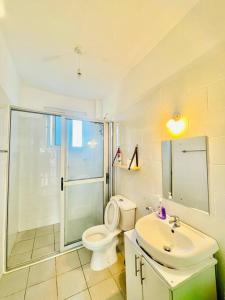 a bathroom with a toilet and a sink and a shower at Mawingu Loft in Malindi