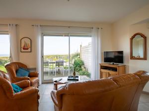 ein Wohnzimmer mit 2 Ledersesseln und einem TV in der Unterkunft Holiday Home Mer d'Iroise 1 - LCQ104 by Interhome in Le Conquet