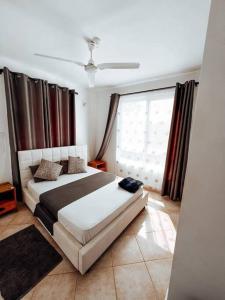um quarto com uma cama e uma grande janela em Mawingu Loft em Melinde
