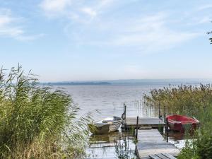 FjälkingeにあるHoliday Home Kjuge Gula Huset by Interhomeの湖の桟橋に2隻の船が停泊している