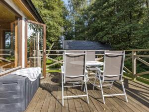 un patio con 2 sillas y una mesa en una terraza en Holiday Home Kjuge Gula Huset - SKO039, en Fjälkinge