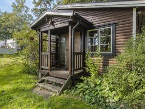 a small cabin with a porch and a window at Holiday Home Kjuge Nya Huset by Interhome in Fjälkinge +16 photos