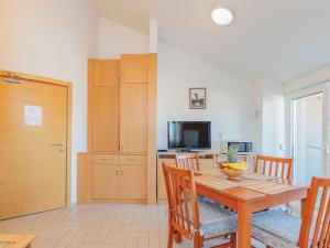 a dining room with a wooden table and a television at Apartment Mlasina-5 by Interhome in Nin