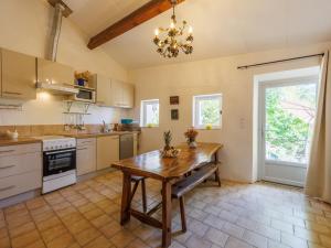 een keuken met een houten tafel in het midden bij Holiday Home La Volte by Interhome in Sainte-Croix-de-Caderle