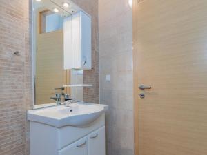 a bathroom with a white sink and a mirror at Apartment Mlasina-6 by Interhome in Nin