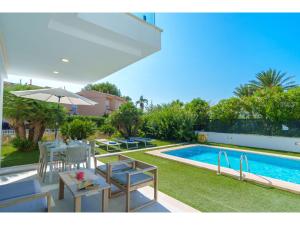 une arrière-cour avec une piscine, une table et des chaises dans l'établissement Holiday Home Villa del Lago 4 by Interhome, à Port d'Alcúdia