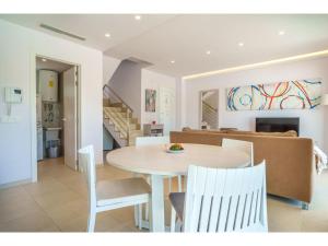 - une salle à manger et un salon avec une table et des chaises dans l'établissement Holiday Home Villa del Lago 4 by Interhome, à Port d'Alcúdia