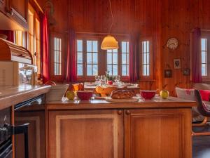 ナンダにあるChalet Bivak by Interhomeの木製の壁のキッチン(食べ物を入れたテーブル付)