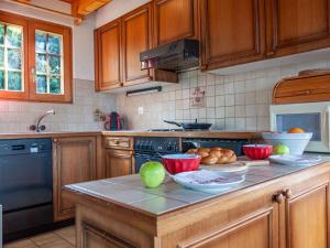 a kitchen with wooden cabinets and a counter with bowls of food at Chalet Bivak by Interhome in Nendaz