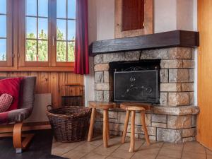 a living room with a stone fireplace with a tv at Chalet Bivak by Interhome in Nendaz