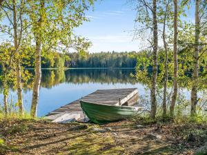 a boat on a dock next to a lake at Holiday Home Niemenkärki by Interhome in Kortteinen