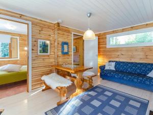 a living room with a blue couch and a table at Holiday Home Jussinlahti by Interhome in Kortteinen