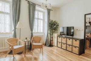 a living room with a tv and chairs at Central 3BD Apartment Old Town Square & Astronomical Clock 100 metres in Prague