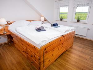 ノルトダイヒにあるHoliday Home Baltrum by Interhomeのベッドルーム1室(大型木製ベッド1台、タオル付)