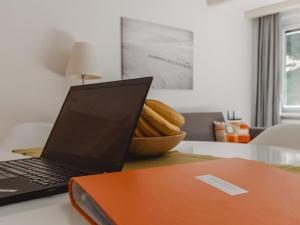un ordenador portátil sentado en un escritorio con un tazón de comida en Apartment Judith Top 13 by Interhome, en Bad Gastein