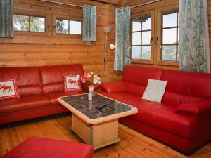 SaclentseにあるChalet Edelweiss by Interhomeのリビングルーム(赤いソファ、テーブル付)