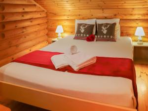 a bedroom with a large bed in a log cabin at Chalet Edelweiss by Interhome in Saclentse