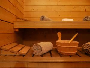 a wooden sauna with a towel and a wooden basket at Chalet Edelweiss by Interhome in Saclentse