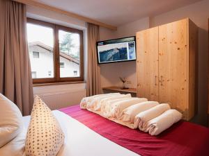 a bedroom with a bed and a tv on the wall at Apartment Falkner-13 by Interhome in Oberlängenfeld