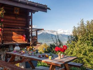 a wooden picnic table with flowers and fruit on it at Holiday Home Le Dahu by Interhome in Nendaz
