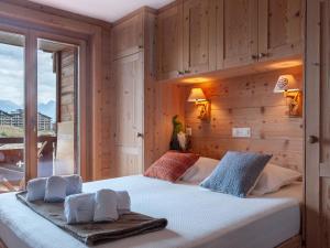 ein Schlafzimmer mit einem großen Bett und einer Holzwand in der Unterkunft Apartment Le Montagnard 4 by Interhome in Nendaz
