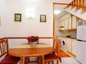 ミアミ・プラトーヤにあるHoliday Home Montalt IX by Interhomeの小さなキッチン(木製テーブル、テーブル、電子レンジ付)