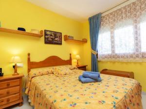 a bedroom with a bed with yellow walls and a window at Holiday Home Montalt IX by Interhome in Miami Platja