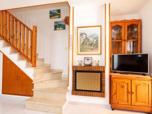 a living room with a staircase and a flat screen tv at Holiday Home Montalt IX by Interhome in Miami Platja +20 photos