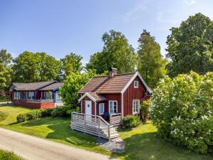 ein rotes Haus auf einem Rasenplatz mit einem Haus in der Unterkunft Chalet Kasen Lillstugan by Interhome in Färgelanda