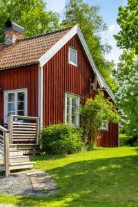 a red house with a porch and a yard at Chalet Kasen Lillstugan by Interhome in Färgelanda