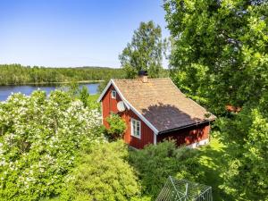 eine Luftansicht eines roten Hauses in den Bäumen in der Unterkunft Chalet Kasen Lillstugan by Interhome in Färgelanda