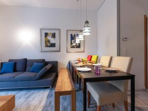 salon ze stołem i niebieską kanapą w obiekcie Apartment IVA by Interhome w mieście Bad Hofgastein