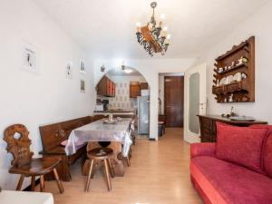 a living room with a table and a red couch at Apartment Ginevra by Interhome in Sauze dʼOulx