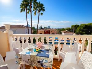 een eettafel op een balkon met palmbomen bij Apartment Garduix by Interhome in Calpe