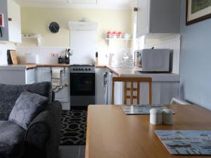 a kitchen with a couch and a table in a room at Holiday Home Flo Anndra by Interhome in Kilmaluag +8 photos