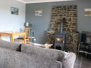 a living room with a couch and a stone stove at Holiday Home Flo Anndra by Interhome in Kilmaluag