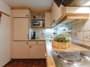 a kitchen with white cabinets and a box of vegetables at Apartment Sonnenappartements by Interhome in Bad Hofgastein