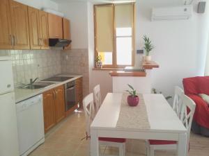 a kitchen with a table and a white table and chairs at Old Town Apartment Mila in Split