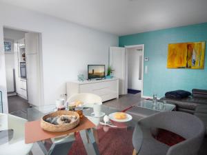 ein Wohnzimmer mit einem Tisch und einem Sofa in der Unterkunft Holiday Home Kegelrobbe by Interhome in Norddeich