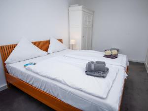 ein Schlafzimmer mit einem weißen Bett mit zwei Säcken darauf in der Unterkunft Holiday Home Kegelrobbe by Interhome in Norddeich