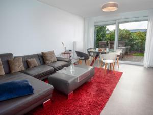 ein Wohnzimmer mit einem Sofa und einem roten Teppich in der Unterkunft Holiday Home Kegelrobbe by Interhome in Norddeich