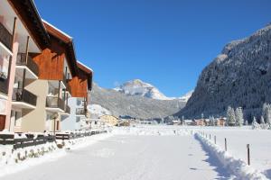 uma rua coberta de neve em frente a um edifício em Casa Del Conte em Mazzin