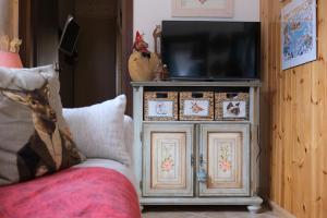 telewizor siedzący na drewnianej szafce w obiekcie Casa Del Conte w mieście Mazzin