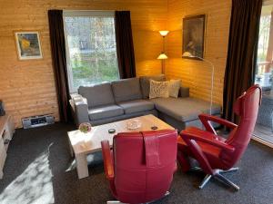 uma sala de estar com um sofá, uma mesa e cadeiras em Chalet Wilsumer Berge by Interhome em Wilsum