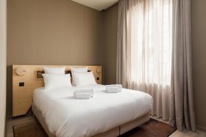 um quarto com uma grande cama branca e uma janela em Gogaille - Gambetta - accès autonome em Limoges
